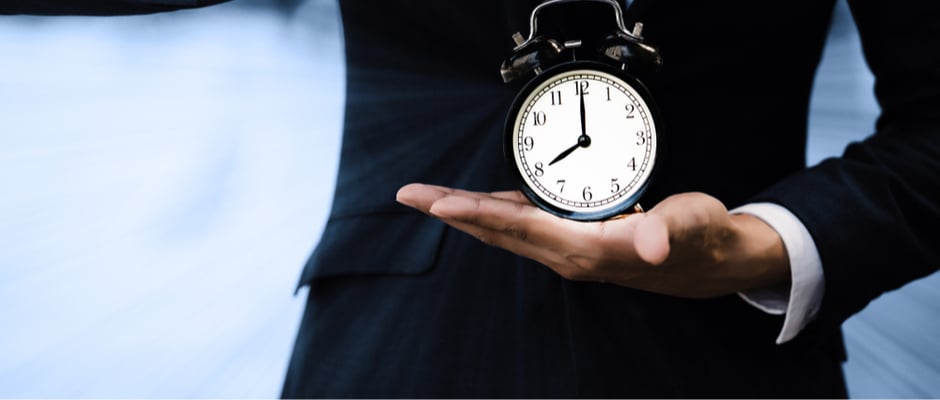 image of businessman holding a clock