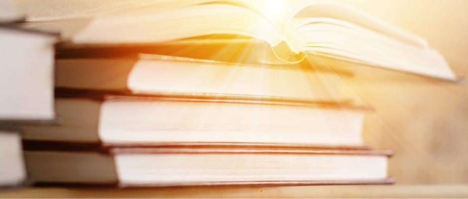 image of stack of books with light coming out of the top book