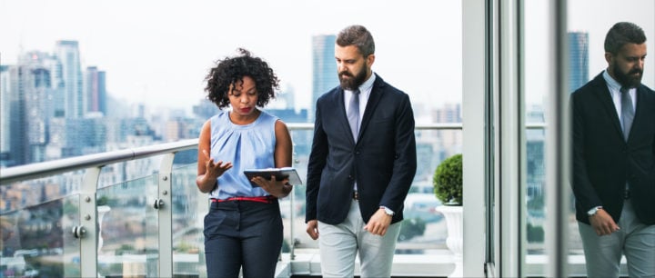 alt image text of a woman and man looking at an ipad in a meeting