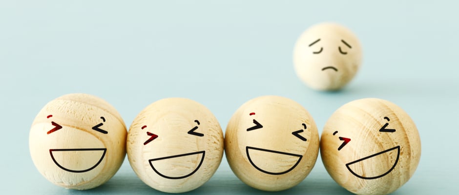 image of group of laughing emoticon faces and one alone look sad and depressed