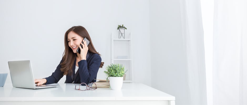 image of business woman at desk on phone to represent prospecting
