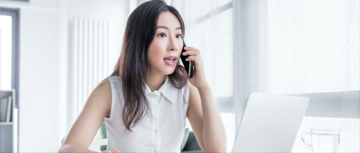 image of woman in front of computer talking on the phone