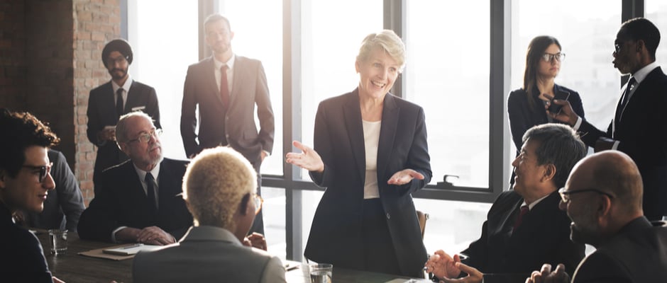 alt text image of woman standing in front of a group leading a meeting