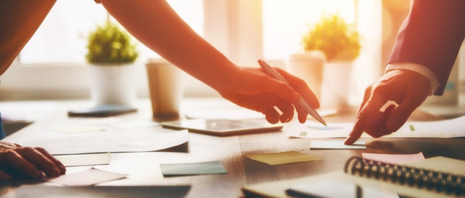 image of hands working with paperwork on a desk