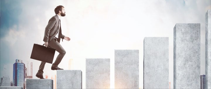 Side view of a man climbing the concrete stairs made in the shape of a graph.