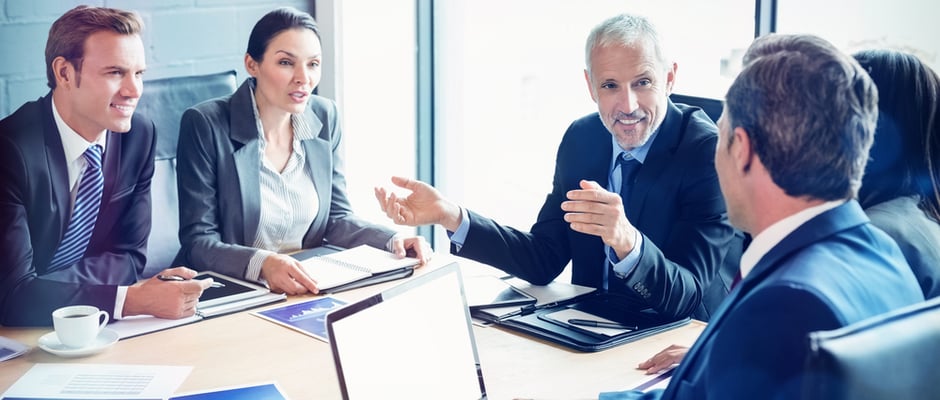 image of business man sitting with other business people at a conference table