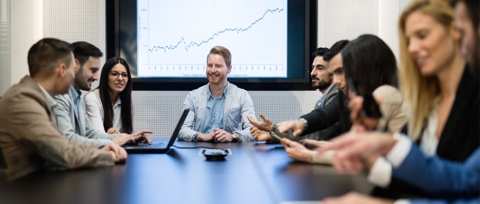 alt text image of someone leading a team meeting around conference table