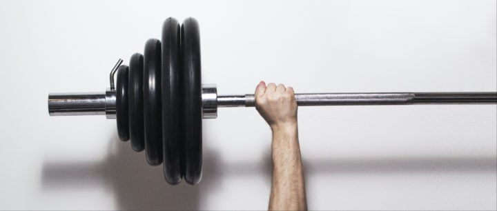 alt image text of arm holding up a barbell with multiple size weights