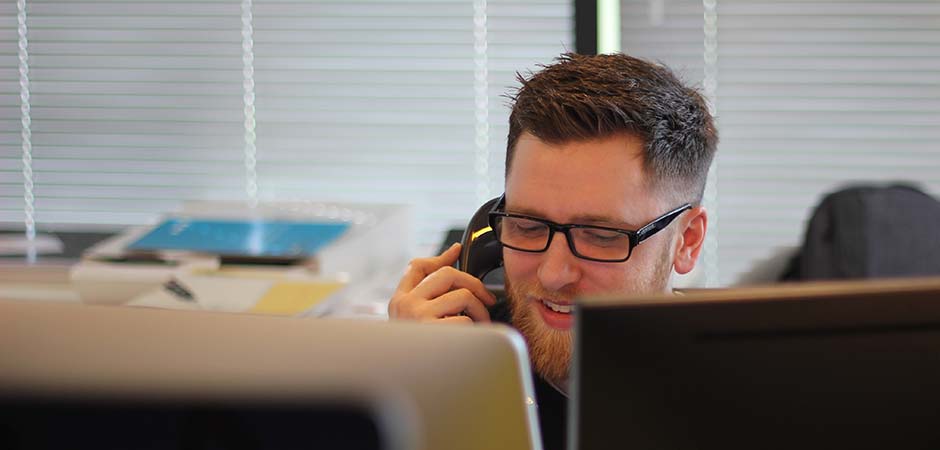 salesman on phone at dual computer screens