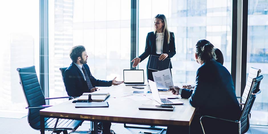 Saleswoman consulting with her clients in a board room