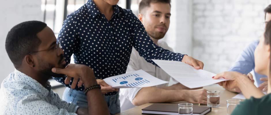 woman handing out charts in a meeting