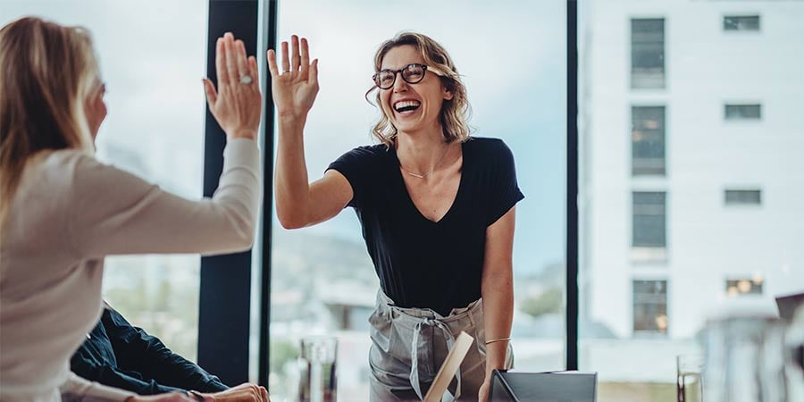 two business women high-fiving