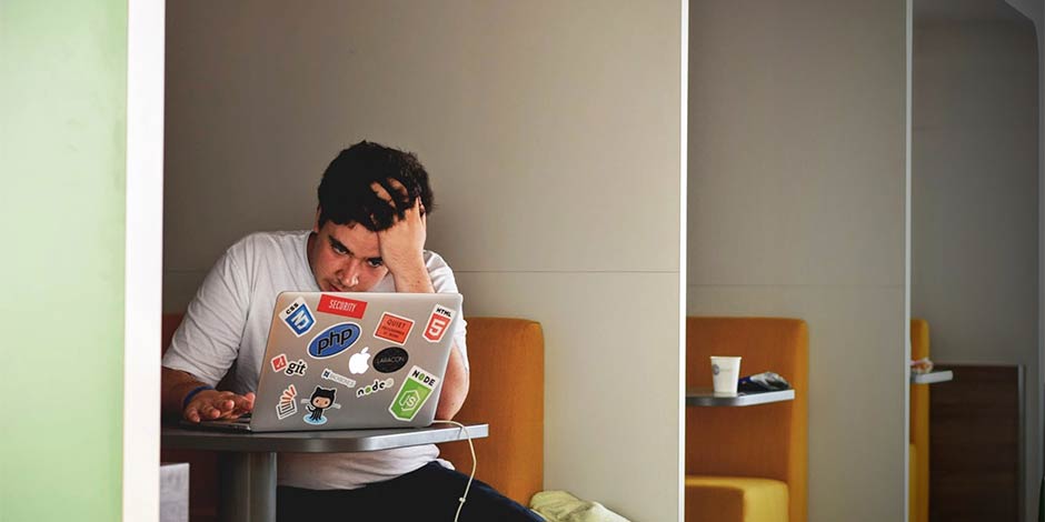 frustrated man working at a laptop