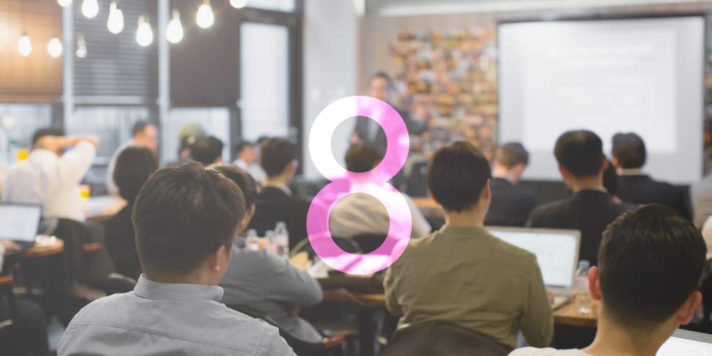 Workers sitting in sales training in conference room