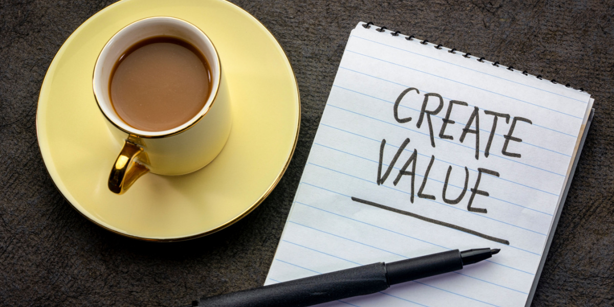 Notepad with "Create Value" written on it next to a cup of coffee