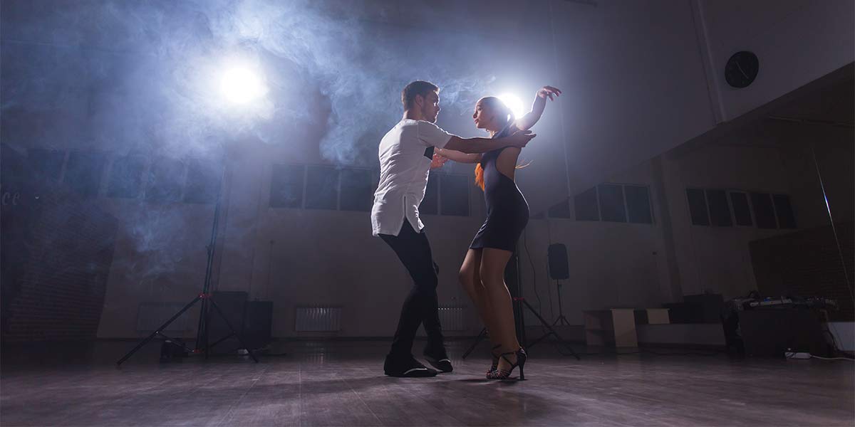 couple ballroom dancing with dramatic back lighting