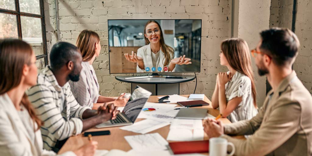 Conference room meeting with virtual guest on tv