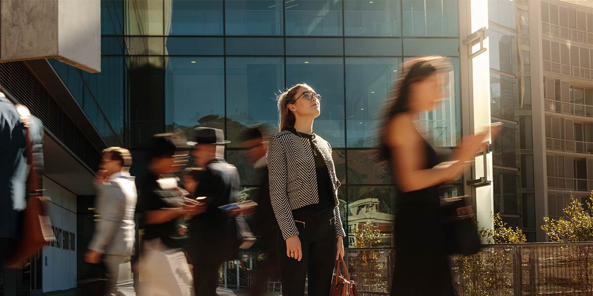 Young businesswoman looking up in a crowd