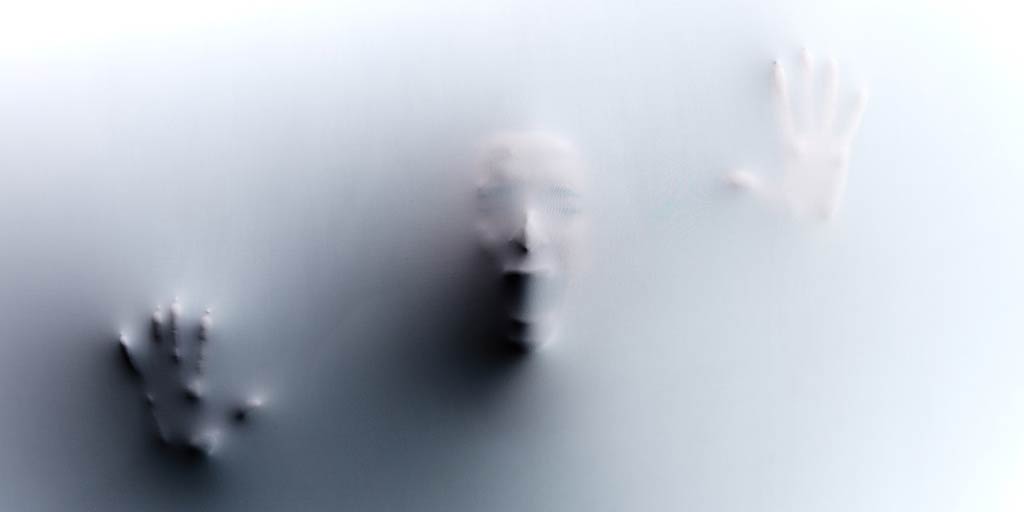 screaming face and hands pushing against a sheet