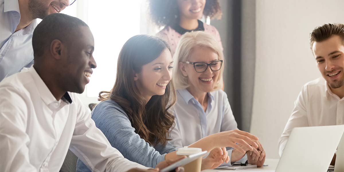 Diverse sales team discussing training at a table