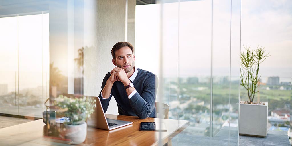 businessman sitting at laptop thinking pensively