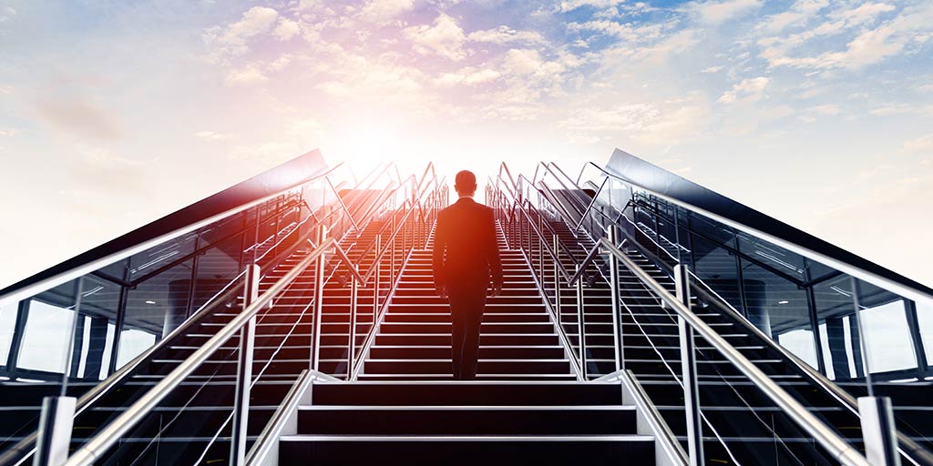 businessman looking up long stairway