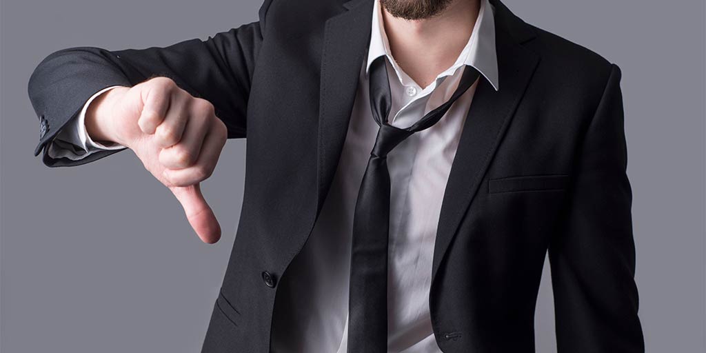 businessman in sloppy suit holding out thumbs down