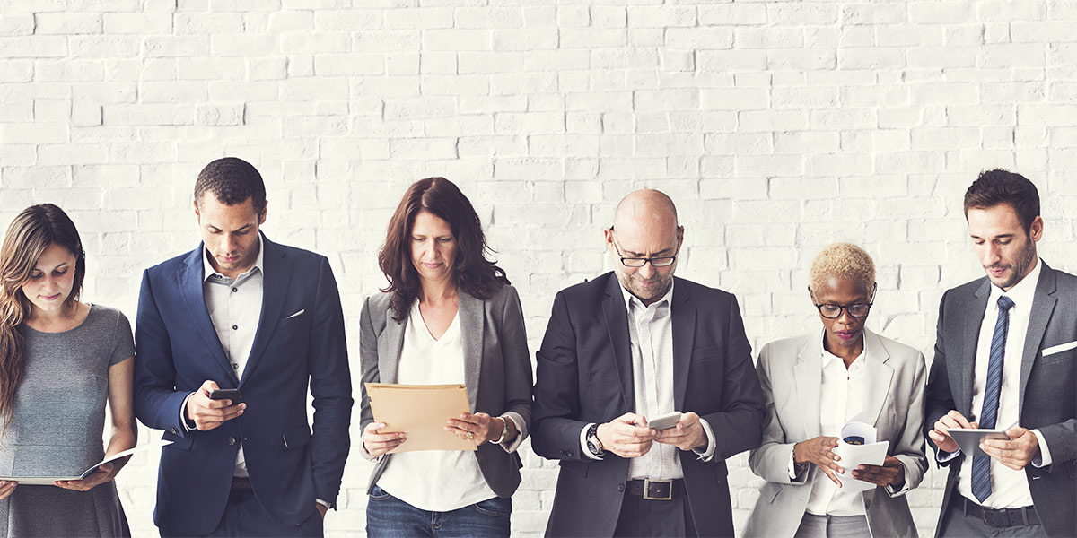 diverse group of business people all distracted by smart phones