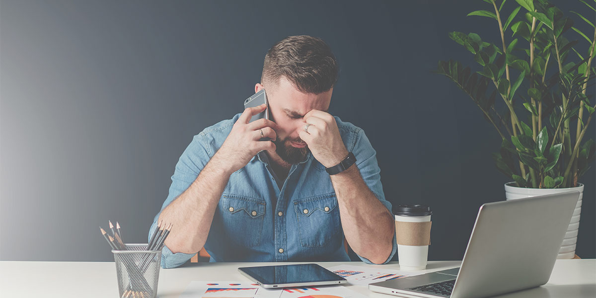 frustrated businessman on the phone at his desk